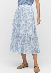 Ljusblå blommas maxi kjol med lagerdesign, gjord av genomskinligt tyg, med en tunn elastisk midjeband och en svävande silhuett.
