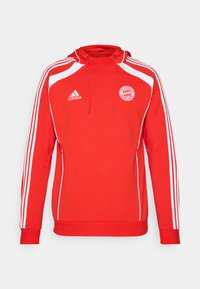 Rød hættetrøje med hvide detaljer og tre hvide striber langs ærmerne. Har FC Bayern München logo og snoretræk i hætten.