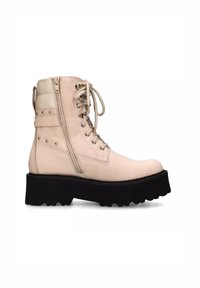 Stivaletto beige in pelle, con una spessa suola piattaforma nera, borchie decorative e zip laterale per una facile calzata. Stringhe sul davanti.