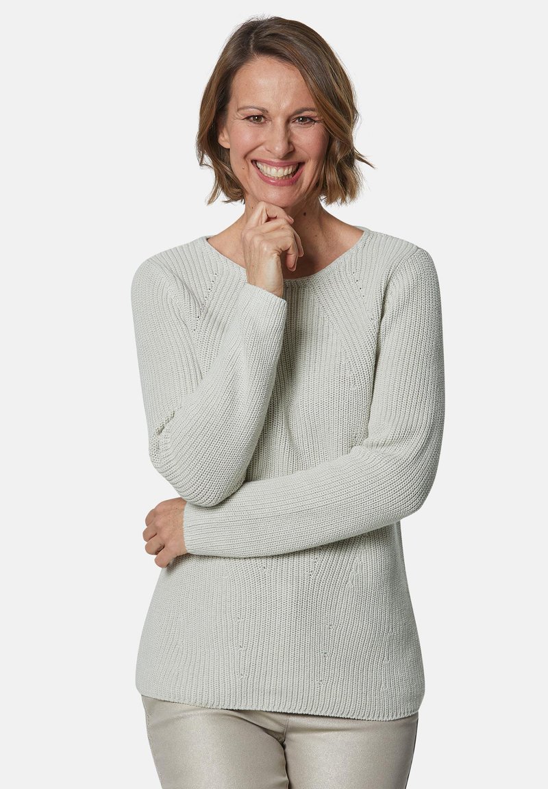 Hellgrauer Strickpullover mit Rundhalsausschnitt, strukturiertem Muster und langen Ärmeln, kombiniert mit glänzenden silbernen Hosen.