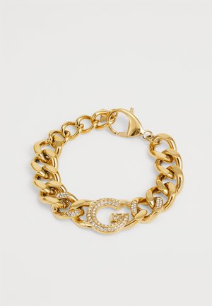 Gouden armband met grote schakels, een kreeftenhaak en een ronde accent met een "G" versierd met heldere strassstenen.