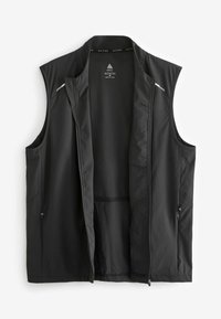 Gilet sans manches noir en tissu léger avec une texture lisse. Dispose de poches latérales et de détails réfléchissants subtils.