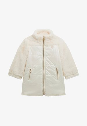 Veste couleur crème avec une partie supérieure en fausse fourrure et une section inférieure matelassée brillante ; dotée d'une fermeture éclair à l'avant et de deux poches zippées sur les côtés.