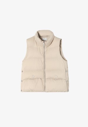 Beige puff-täidisvest kõrge kraega, ees lukuga ja nupuga detailidega. Omab tikandit ja siledat, läikivat tekstuuri.