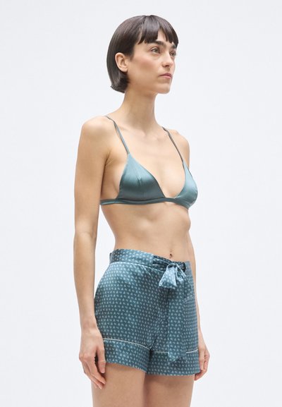 Kék szatén háromszög alakú melltartó vékony pántokkal, hozzá illő mintás rövidnadrággal, amely megkötővel és laza szabással rendelkezik.