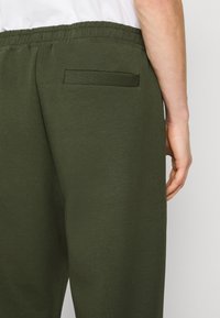 BOSS HADIKO - Treniņtērpa apakšdaļas - open green