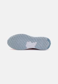 Semelle de sneaker Nike, avec une semelle en caoutchouc transparent dotée d'éléments de traction ovales, principalement de couleur bleu clair avec des détails de surface texturés.