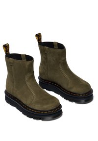 Botines de ante verde oliva con suela de goma negra. Presentan una puntera redonda, inserciones elásticas en los laterales y una lengüeta amarilla en el talón.