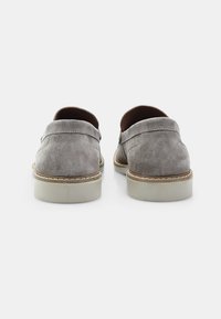 Pantofi slip-on din suede gri, cu vârf rotund și detalii cusute. Talpă ușoară, cu amortizare și suprafață texturată, având un design minimalist.