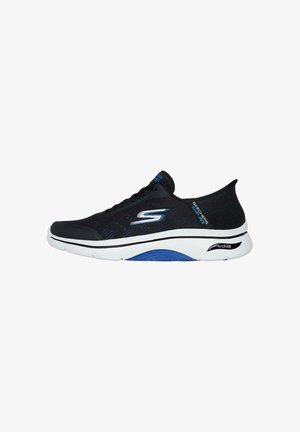 Zapatillas deportivas negras con parte superior de malla, entresuela blanca y acentos azules. Cuentan con una puntera redondeada y la marca "Arch Fit" en el lateral.