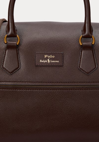 Sac à main en cuir texturé marron foncé avec deux poignées, fermeture éclair dorée et logo Polo Ralph Lauren embossé doré sur le devant.