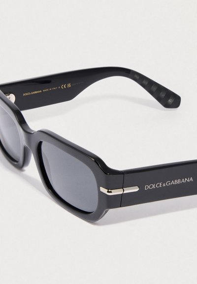 Fekete téglalap alakú napszemüveg szürke lencsékkel, fényes felülettel, strukturált fekete szárakkal és ezüst logóval a kereten.