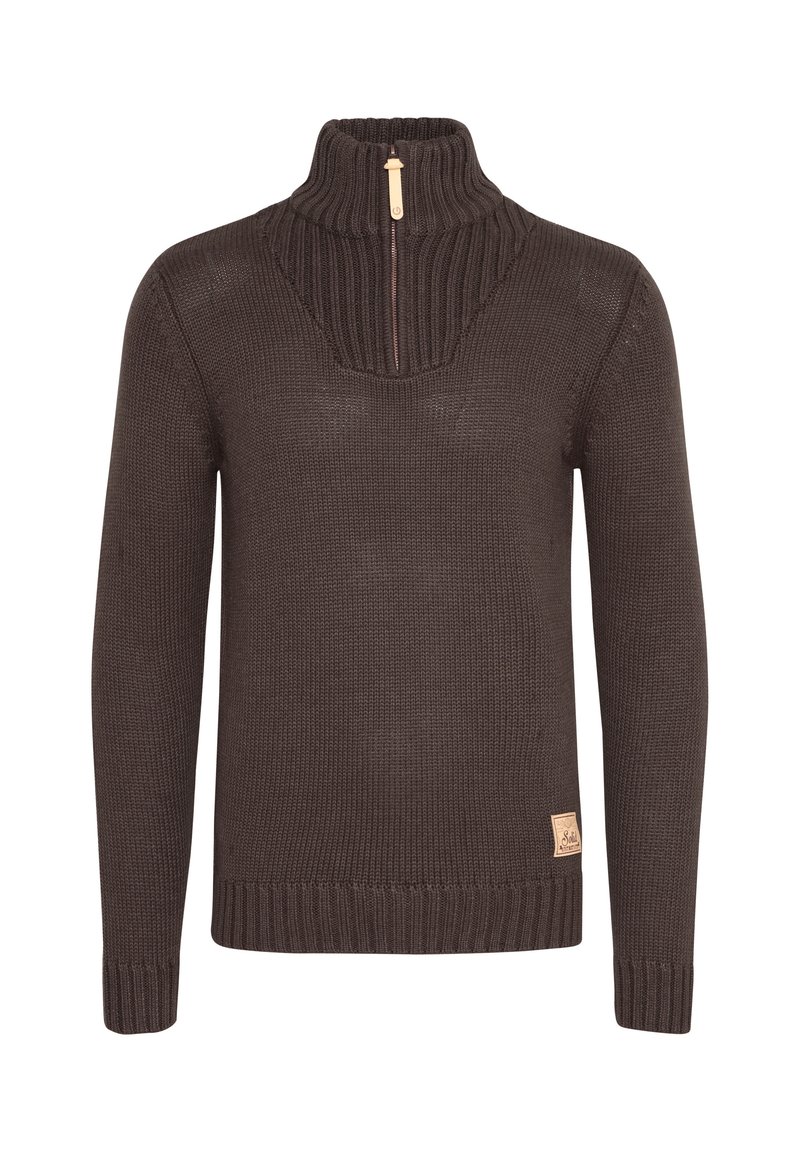 Dunkelbrauner, gestrickter Pullover mit hohem Kragen, halbem Reißverschluss, Rippendetails und einem kleinen Markenetikett an der unteren Seite.