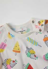 Korte mouwen crème shirt met kleurrijke prints van ijs en fruit. Drukknopen op de schouder voor gemakkelijk aan- en uittrekken. Zachte katoenen stof.