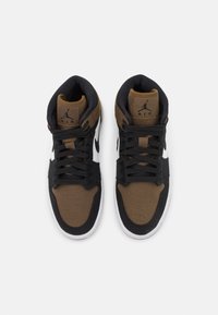 High-top sneakers featuring a brown and black fabric upper, white Swoosh, black laces, padded collar, and textured detailing.