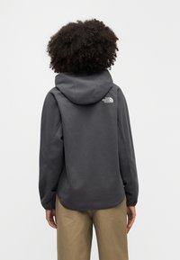 Γκρι φλις φούτερ με κουκούλα και κορδόνι. Διαθέτει ριμπ μανσέτες, άνετη εφαρμογή και μικρό λευκό λογότυπο στο πίσω μέρος. Μαλακή υφή.