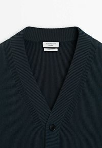 Donkergroen geribde cardigan met een v-hals, knoopsluiting en een "Massimo Dutti" label aan de binnenkant van de kraag. Zachte textuur en een getailleerd design.