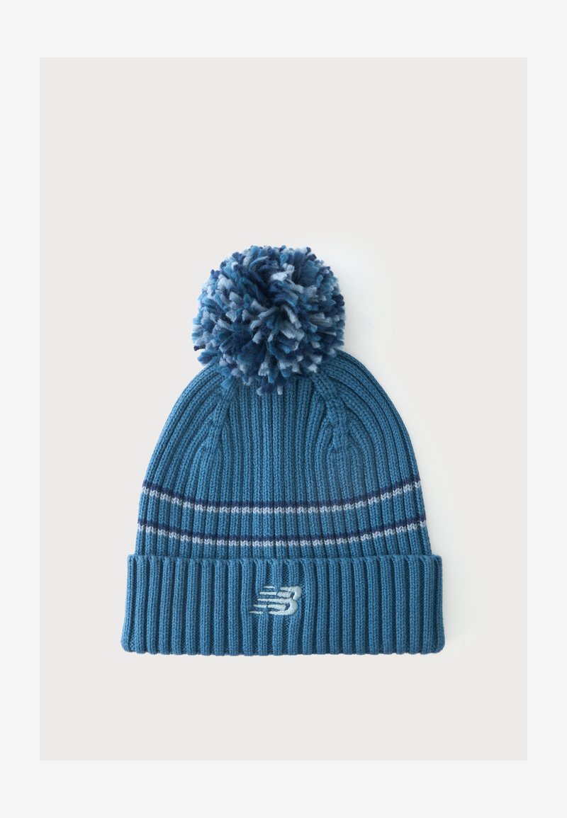 Bonnet tricoté bleu avec un grand pompon sur le dessus, deux bandes blanches horizontales et un logo New Balance sur le revers.