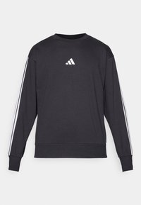Sweatshirt preto de gola redonda com logo branco da Adidas, apresentando riscas brancas ao longo das mangas. Feito de um tecido texturizado em mistura de algodão.
