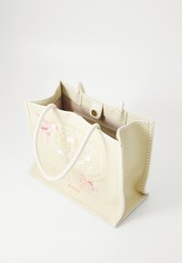 Borsa tote in tela di un giallo chiaro con un design floreale ricamato. Caratterizzata da due manici testurizzati e una chiusura a scatto magnetico.