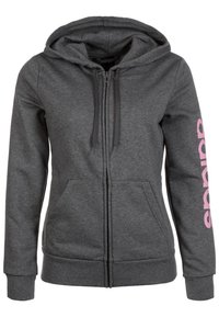 Sweat à capuche gris zippé avec une capuche, des poches kangourou et des lettres roses sur la manche. Fabriqué dans un tissu doux et texturé.