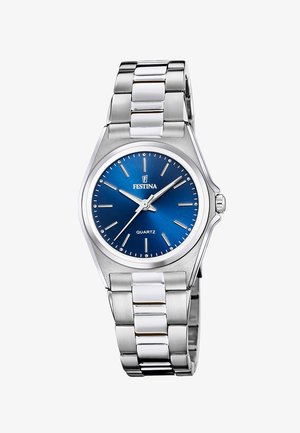Montre à quartz argentée avec un cadran bleu, des index heures argentés et un bracelet en acier inoxydable poli agrémenté de maillons en céramique blanche.