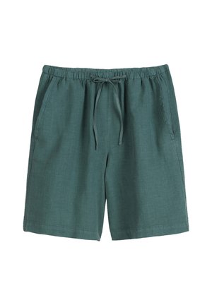 Shorts en lin verts avec une taille élastique, un cordon de serrage et des poches latérales. Texture lisse, design jusqu'au genou et sans motifs visibles.
