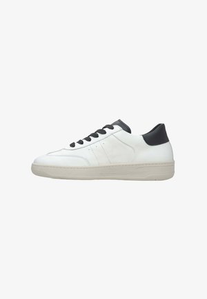White leather sneaker with a textured finish, black accents on the heel, and flat laces. Features a chunky, light-colored rubber sole.