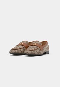 Brown loafers with a patterned textile upper, featuring a smooth leather band and gold-tone hardware detail. Flat sole with a rounded toe.