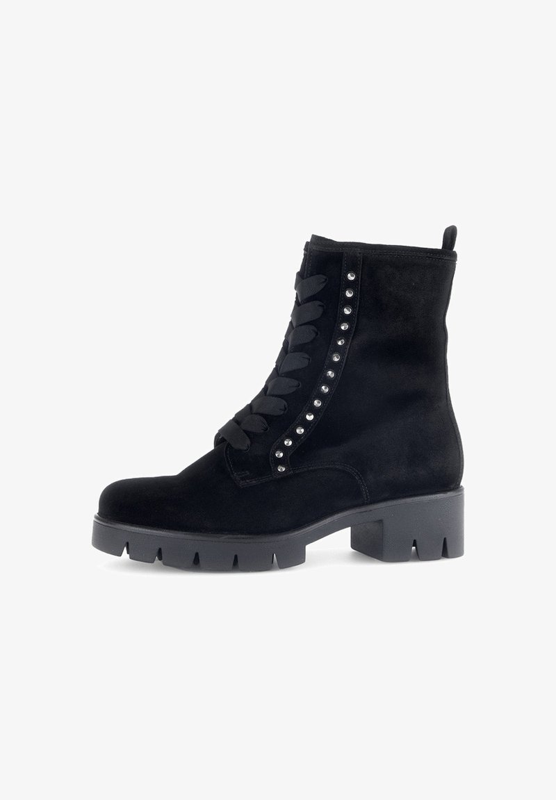 Zwarte suede enkellaars met platte, stevige zool, decoratieve studs langs de zijkant en текстiele veters voor het sluiten.