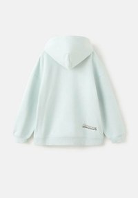 Světlomodrá mikina s kapucí vyrobená z měkké látky. Má klokánčí kapsu a malou "Minecraft" značku u lemu.