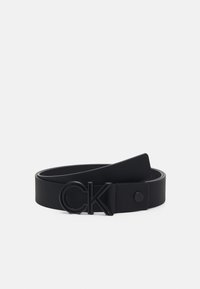 Cintura in pelle nera con finitura testurizzata, fibbia con logo "CK" nero ben visibile e cinturino liscio con chiusura a pressione.