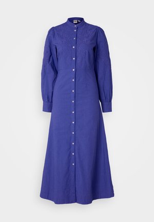 Vestido de manga larga y cuello abotonado en tejido azul oscuro liso, con bordado floral en el pecho y mangas con puños fruncidos.