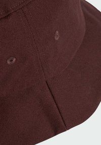 Maronfarbener Bucket Hat aus strukturiertem Stoff mit sichtbaren Nähten. Verfügt über vier Belüftungsösen und einen geschwungenen Schirm.