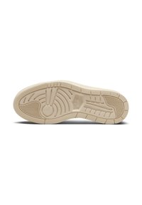 Semelle d'une chaussure Nike Air Jordan beige montrant des motifs détaillés de la bande de roulement et des logos sur un fond blanc propre.