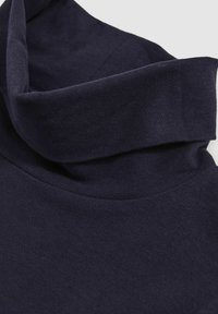 Navy modrý svetér s rolákom vyrobený z mäkkej bavlnenej tkaniny; má vysoký prehnutý golier a hladkú, jednoliate textúru.