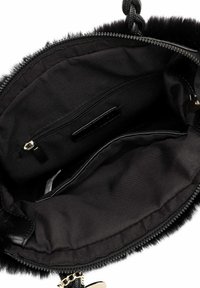 Binnenkant van een zwarte bont handtas met een textielen voering. Voorzien van een ritsvak en een gladde stoffen textuur. Zachte randen en geen zichtbaar beslag.