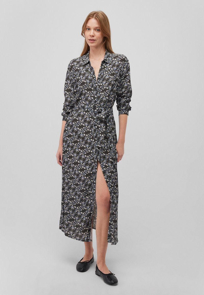 Schwarz-blumiges Kleid mit langen Ärmeln, Knopfverschluss vorne und Taillengürtel. Hat einen schlitz bis zum Oberschenkel und ein gemustertes Gewebe mit blauen und weißen Akzenten.