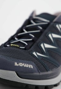 Marinefarbene Mesh-Laufschuhe mit weißen Schnürsenkeln, strukturiertem Obermaterial und kontrastierenden Akzenten. Enthält Lowa-Branding und eine strapazierfähige Gummisohle.
