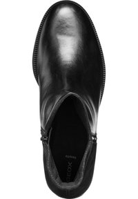 Black ankle boot featuring a shiny leather upper, a side zipper, and a textured sole. Designed with a rounded toe and minimal hardware.
