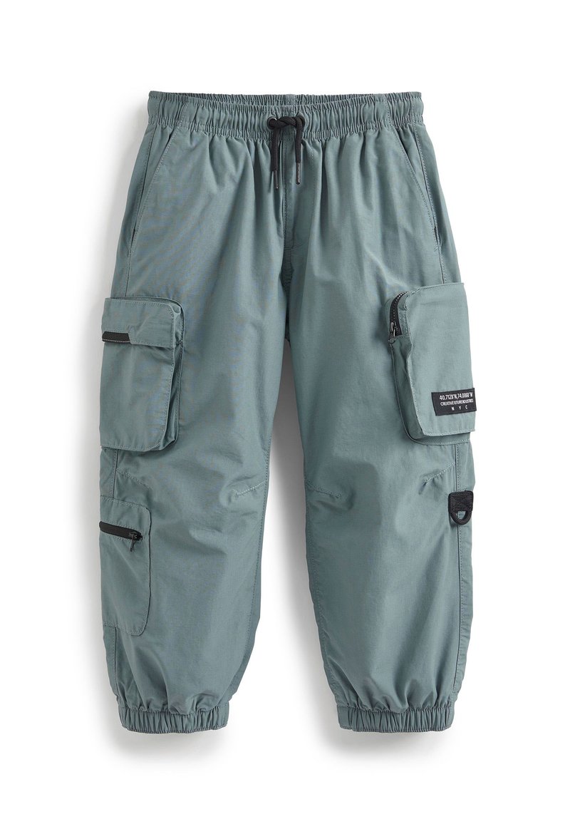 Pantalons cargo en tissu bleu clair-gris avec une taille élastique et un cordon de serrage. Dotés de multiples poches et fermetures éclair pour le rangement.