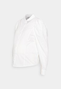 Camisa branca de botão com mangas bufantes, feita de algodão. Apresenta um colarinho clássico e um corpo ajustado com uma barra arredondada.