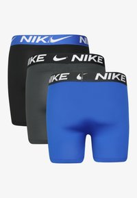 Drie paar fitted shorts in zwart, grijs en blauw; elk met een gecertificeerd elastische tailleband met "NIKE" in witte letters.