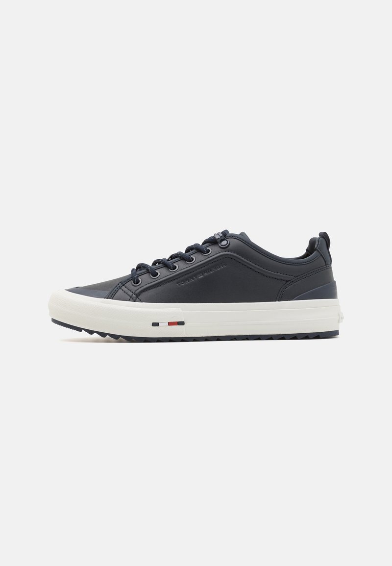 Marineblaue Leder-Sneaker mit weißer Gummisohle, runder Zehenpartie und blauen Schnürsenkeln. Verfügt über ein strukturiertes Obermaterial und kleinen, mehrfarbigen Akzent in der Nähe der Ferse.