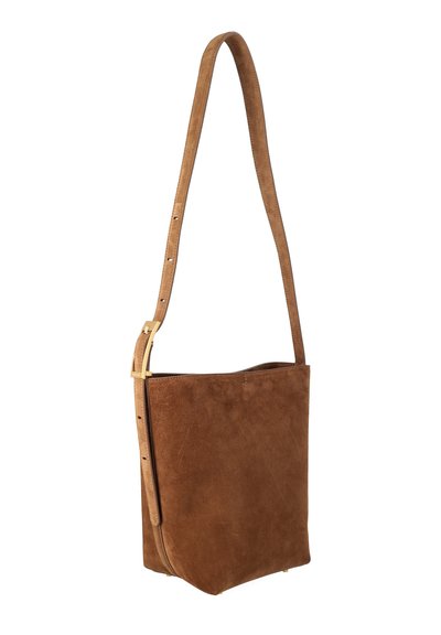 Καφέ ορθογώνια τσάντα χιαστί από σουέντ με ρυθμιζόμενο ιμάντα και χρυσή αγκράφα, όρθια σε λευκό φόντο.