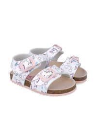 Sandalias blancas con patrones de unicornios y arcoíris, suelas de corcho, tiras rosas y hebillas ajustables. Diseño plano y abierto con una plantilla texturizada.