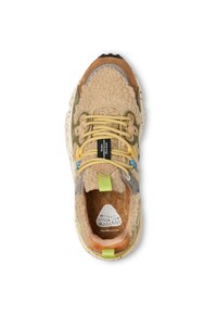 Sneaker beige e verde con una parte superiore texturizzata e pelosa, lacci gialli e suola bianca maculata. Presenta accenti in pelle e una soletta in sughero.
