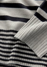 Matière tricotée rayée avec de larges rayures horizontales gris et noir, avec des accents côtelés gris aux bords, texture lisse.