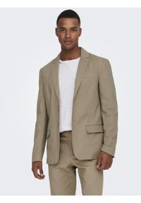 Blazer color marrón claro hecho de una tela texturizada, con un diseño de una sola fila de botones, dos bolsillos frontales y estilo de solapa muesca.