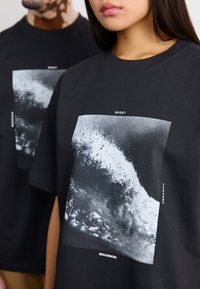 Salomon ALL THAT RIDEZ TEE UNISEX - Μπλουζάκι με στάμπα - deep black